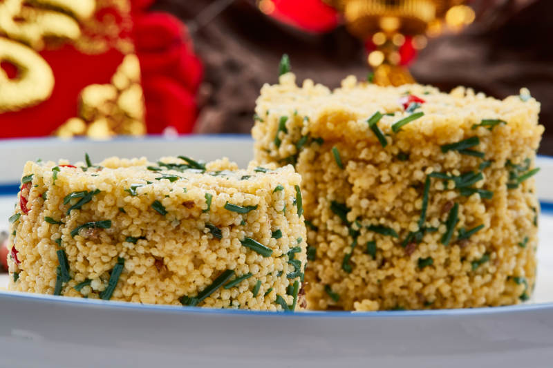 白色瓷盘装的的韭菜小米糕图片