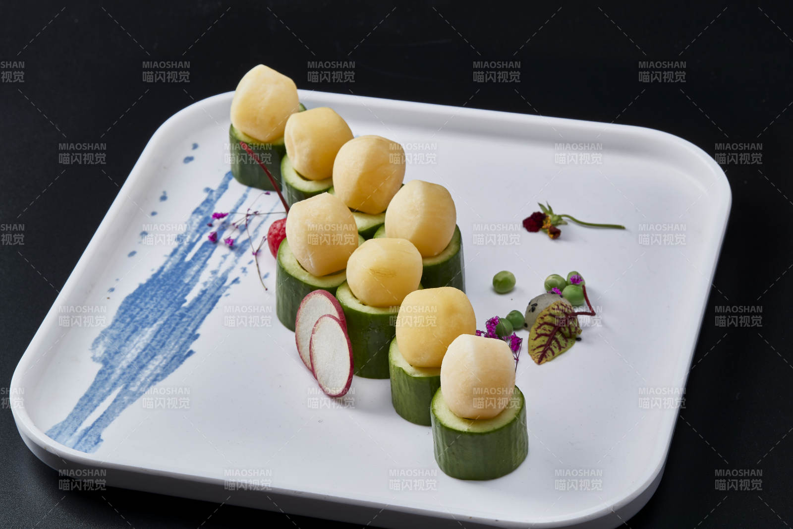 黑色背景上的创意美食手打马铃薯球配乳瓜段图片