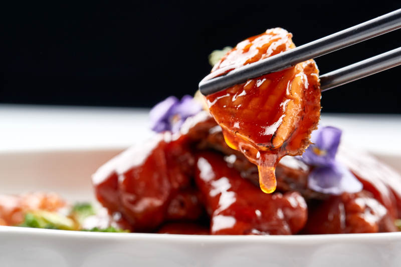 白色瓷盘装的酱烧猪肘鲜鲍鱼图片