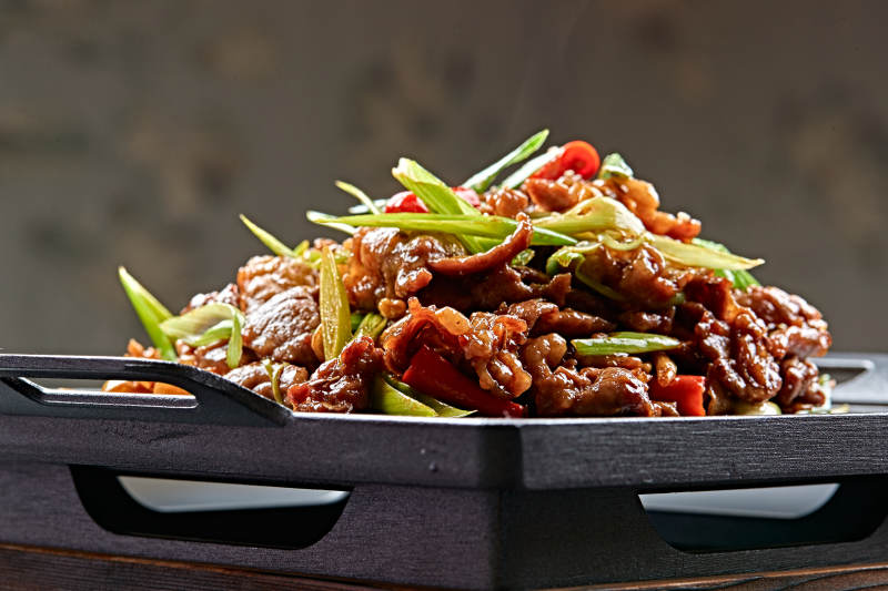 黑铁板盛装的湘味鲜辣铁板黄牛肉图片