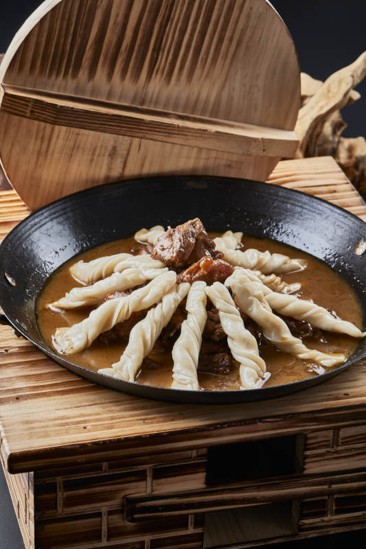 精美餐具装的铁锅炖柴鸡块配面花卷棍儿图片