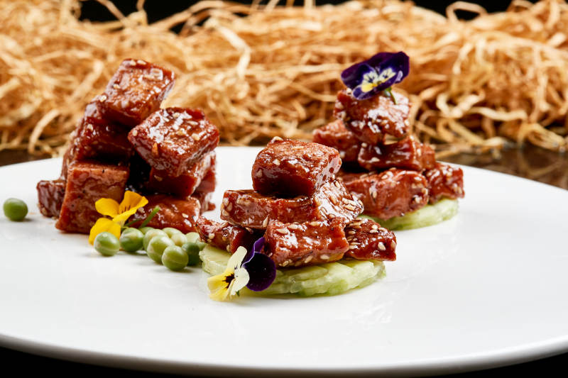 白色瓷盘装的酱腌杏鲍菇图片