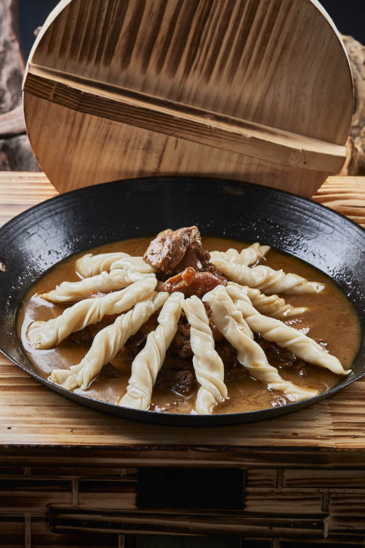 精美餐具装的铁锅炖柴鸡块配面花卷棍儿图片