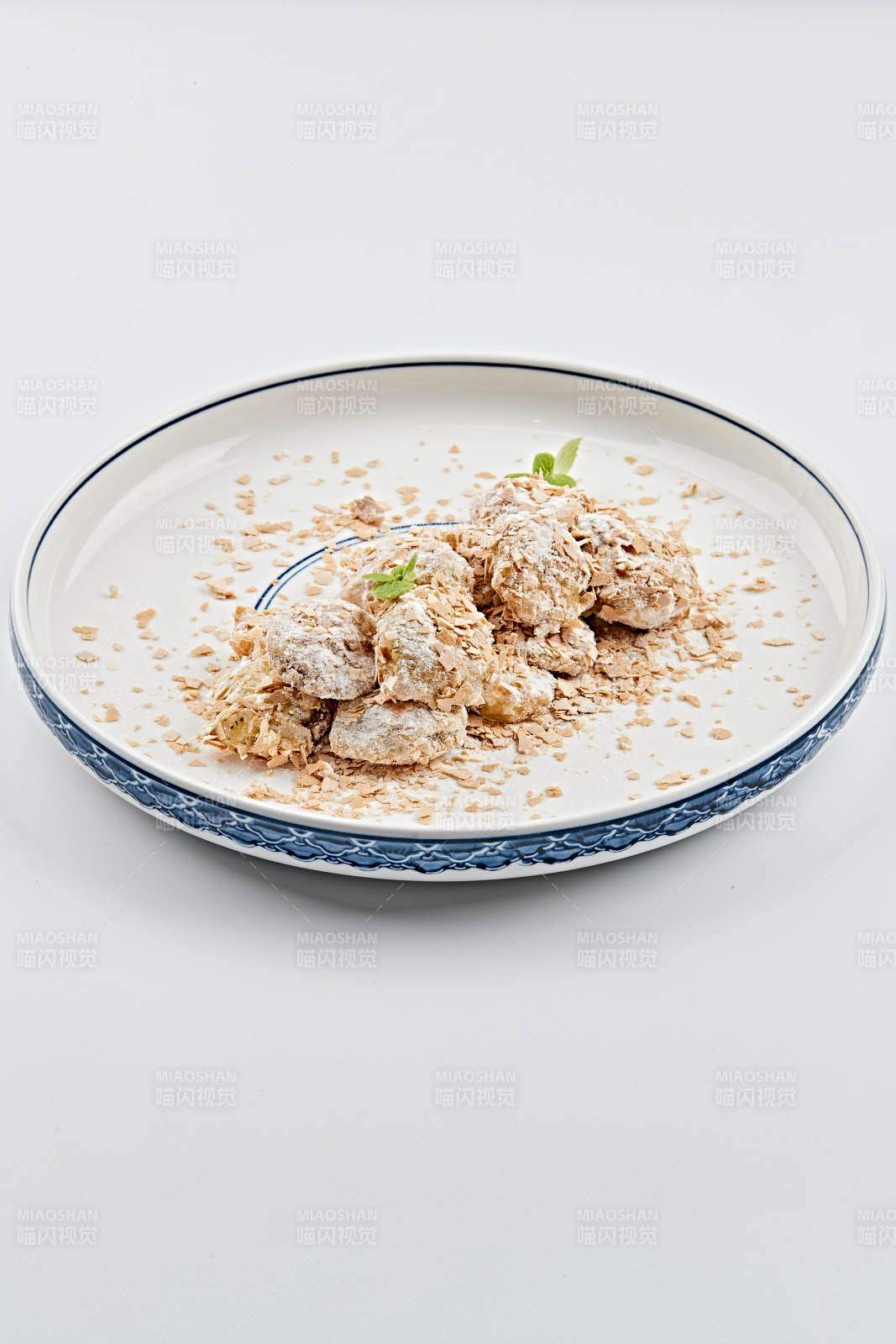 白色青花瓷盘装的香甜麦片炸茄盒图片