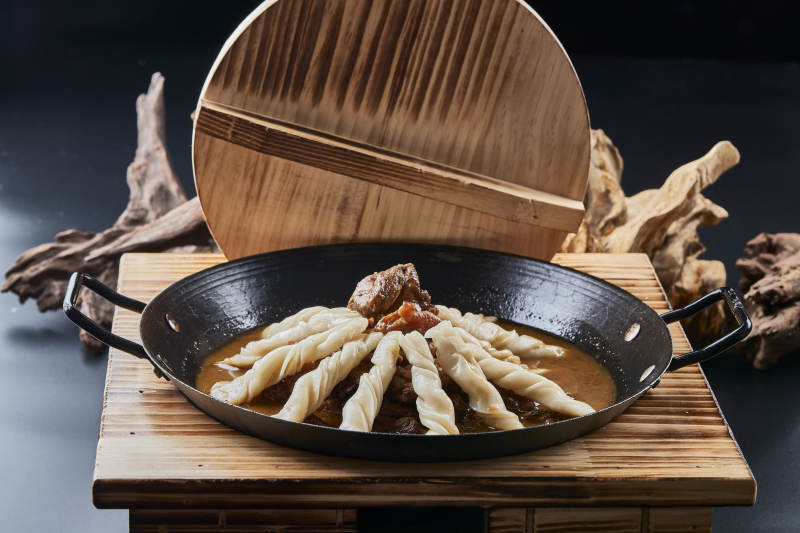 精美餐具装的铁锅炖柴鸡块配面花卷棍儿图片