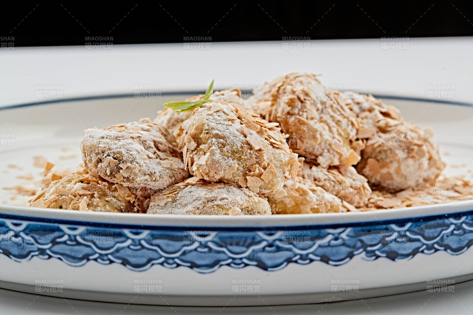 白色青花瓷盘装的香甜麦片炸茄盒图片