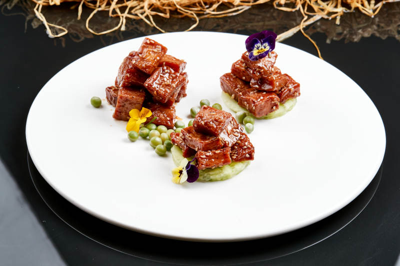 白色瓷盘装的酱腌杏鲍菇图片