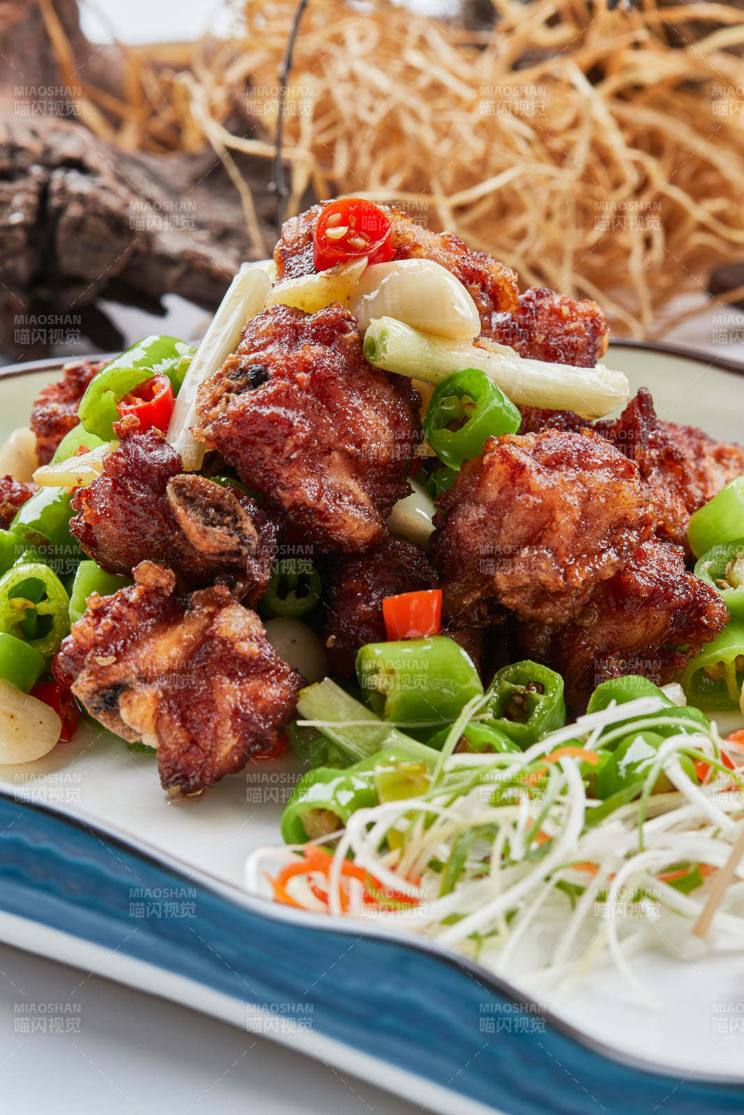 白色瓷盘装的的蒜香米椒烧鸡块图片