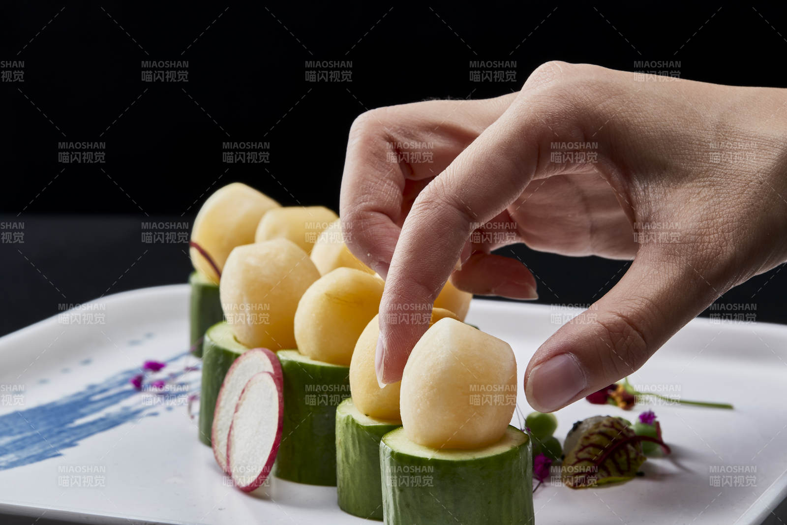 黑色背景上的创意美食手打马铃薯球配乳瓜段图片