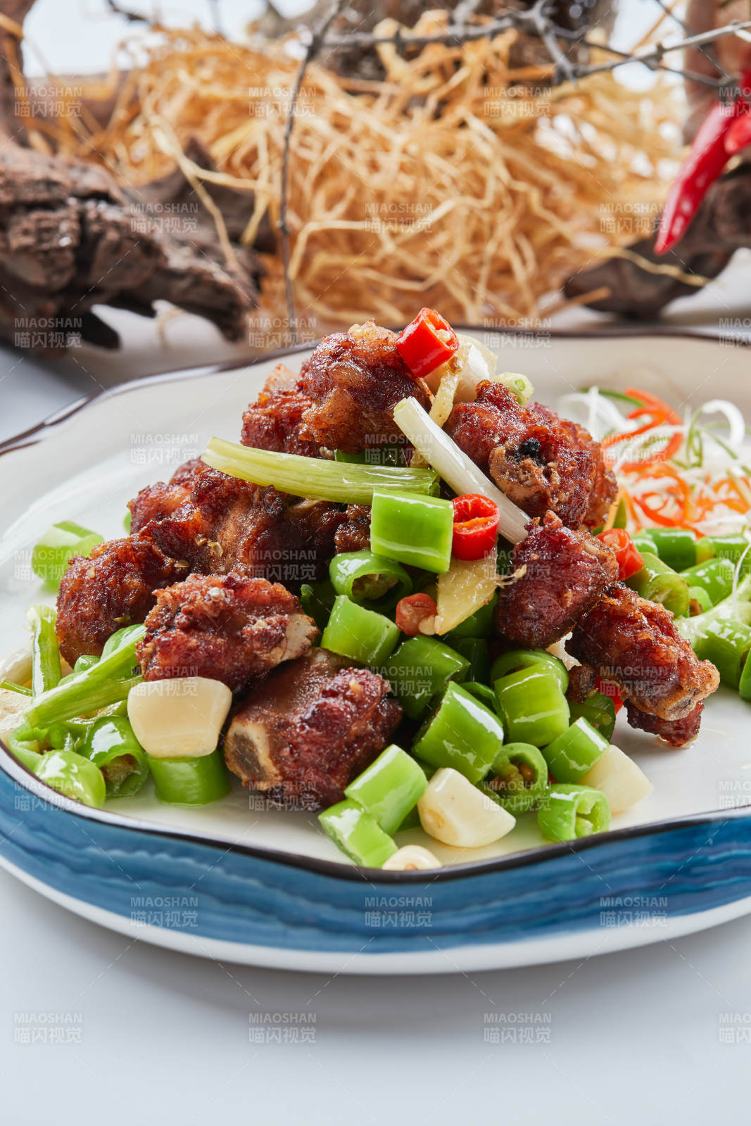 白色瓷盘装的的蒜香米椒烧鸡块图片
