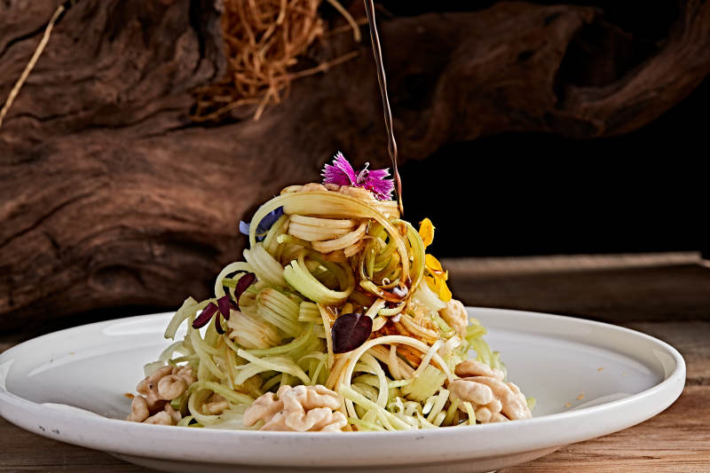 白色瓷盘装的浇汁桃仁西芹丝图片