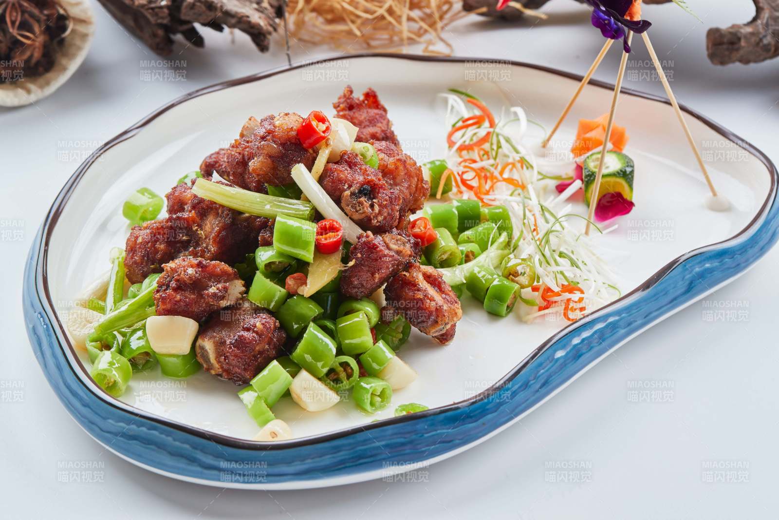 白色瓷盘装的的蒜香米椒烧鸡块图片