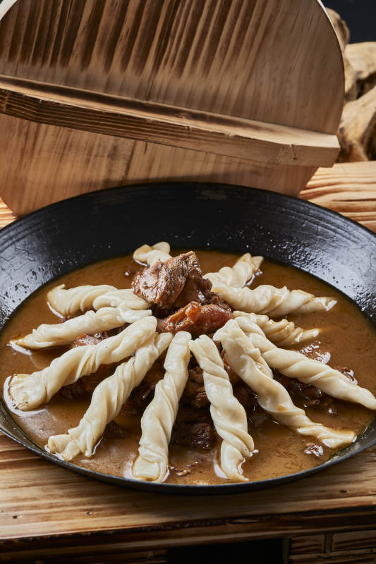 精美餐具装的铁锅炖柴鸡块配面花卷棍儿图片