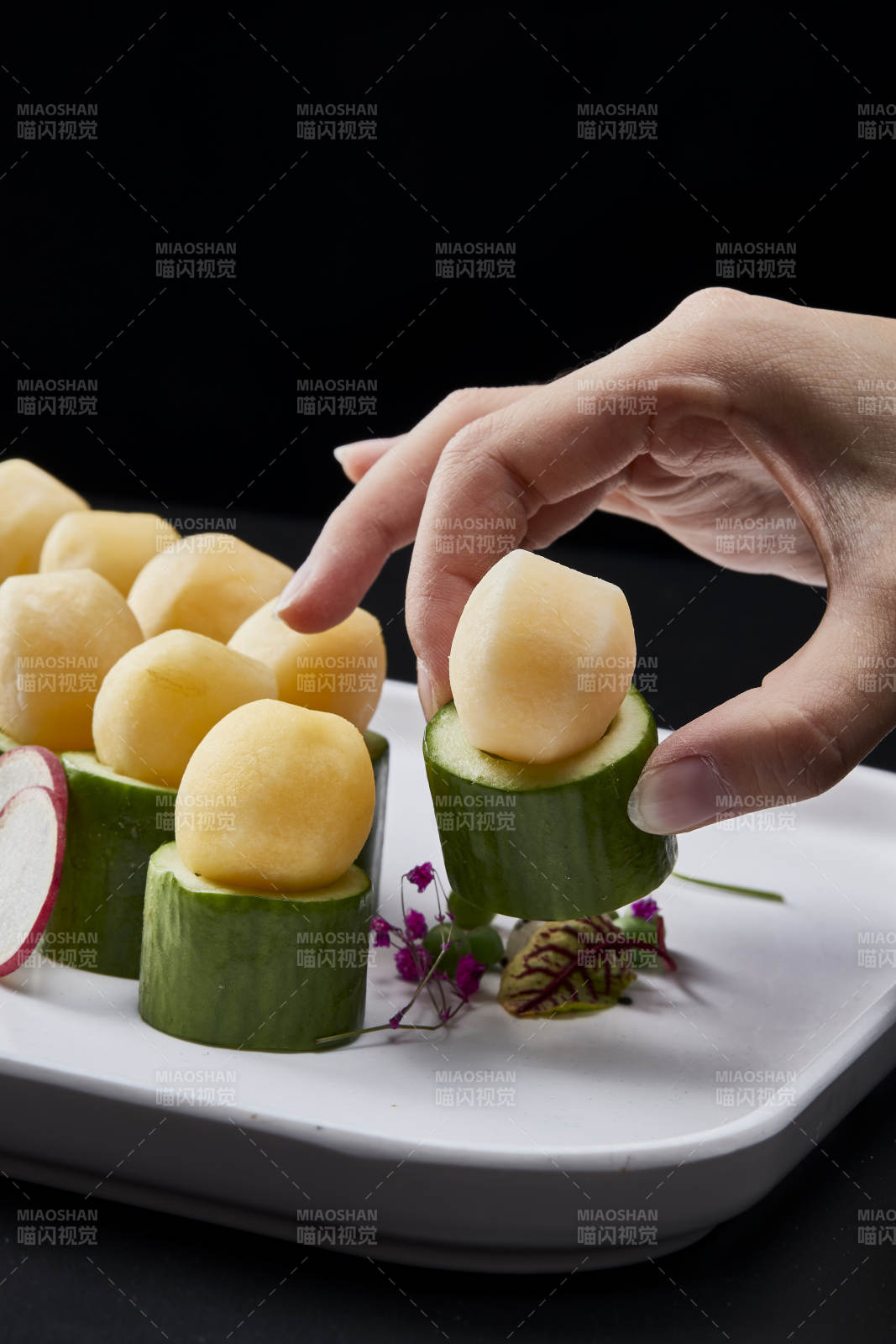 黑色背景上的创意美食手打马铃薯球配乳瓜段图片