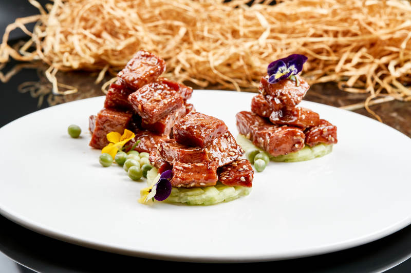 白色瓷盘装的酱腌杏鲍菇图片