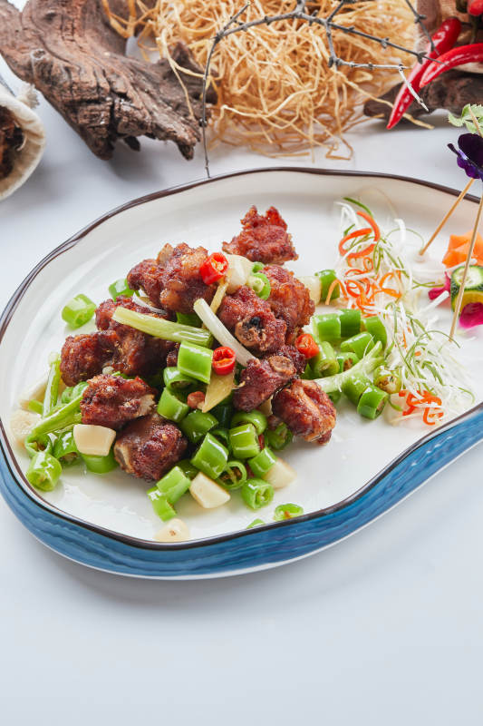 白色瓷盘装的的蒜香米椒烧鸡块图片