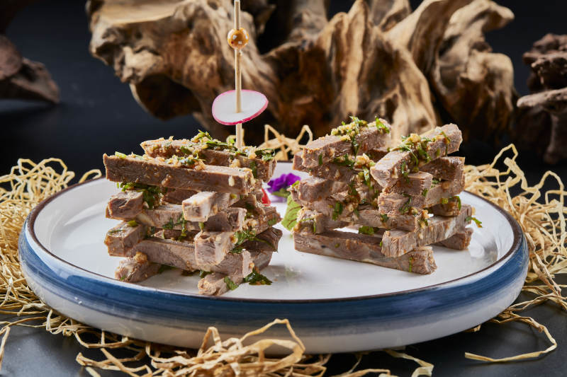 白色圆瓷盘装的蒜香小驴肉图片