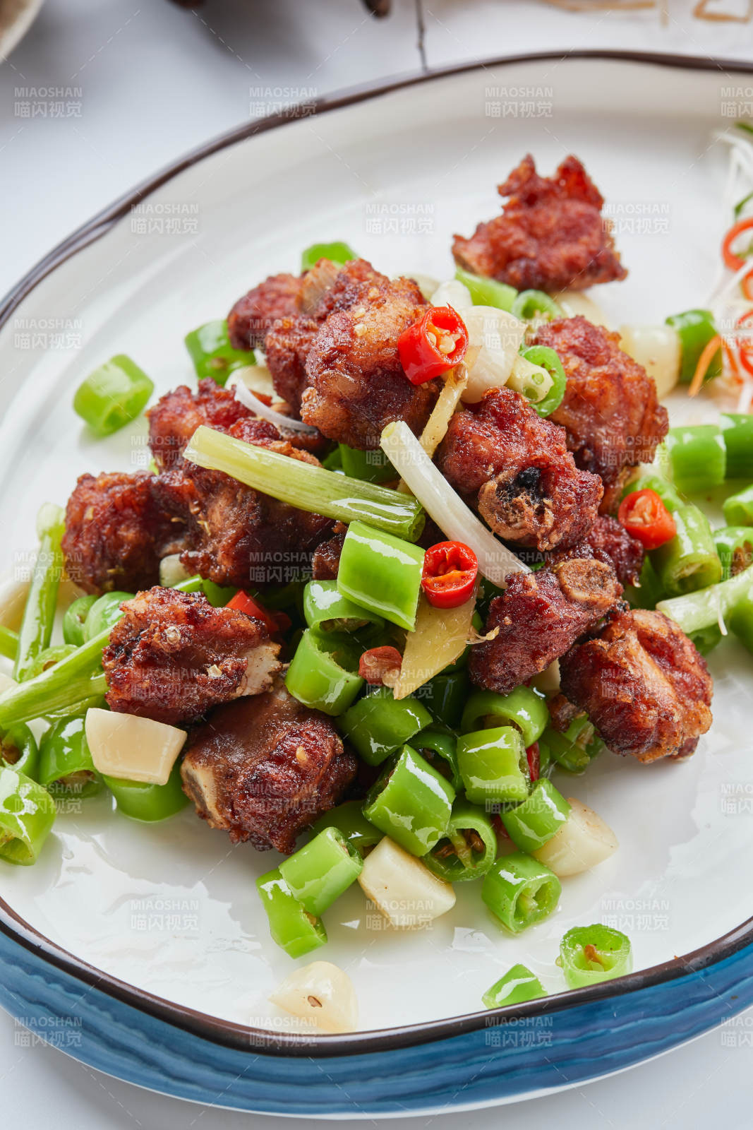 白色瓷盘装的的蒜香米椒烧鸡块图片