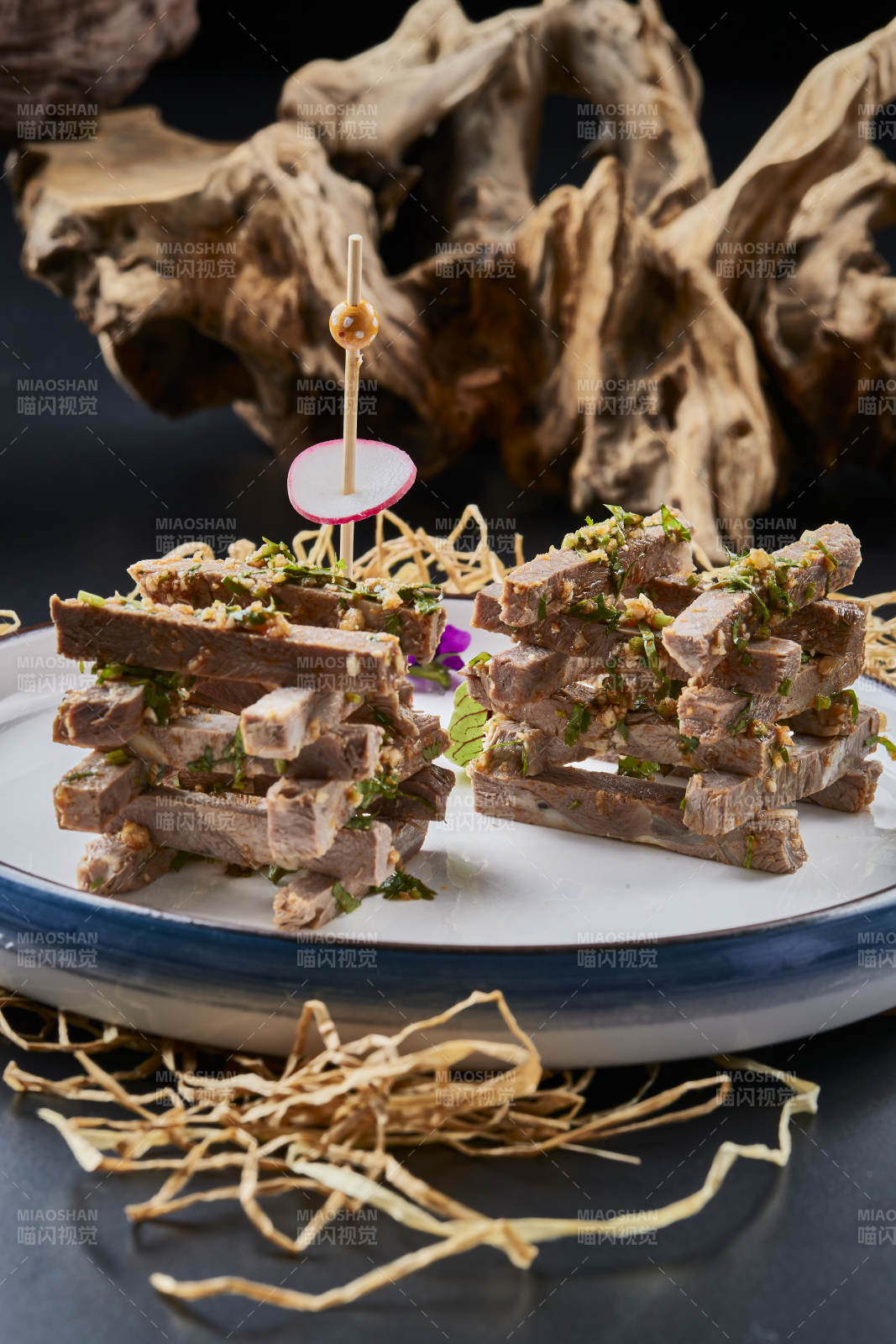 白色圆瓷盘装的蒜香小驴肉图片