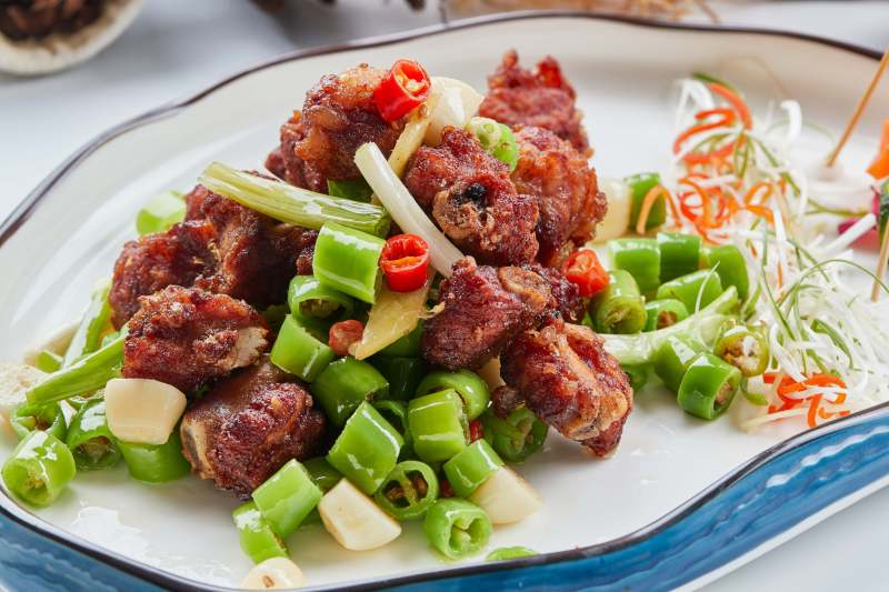 白色瓷盘装的的蒜香米椒烧鸡块图片