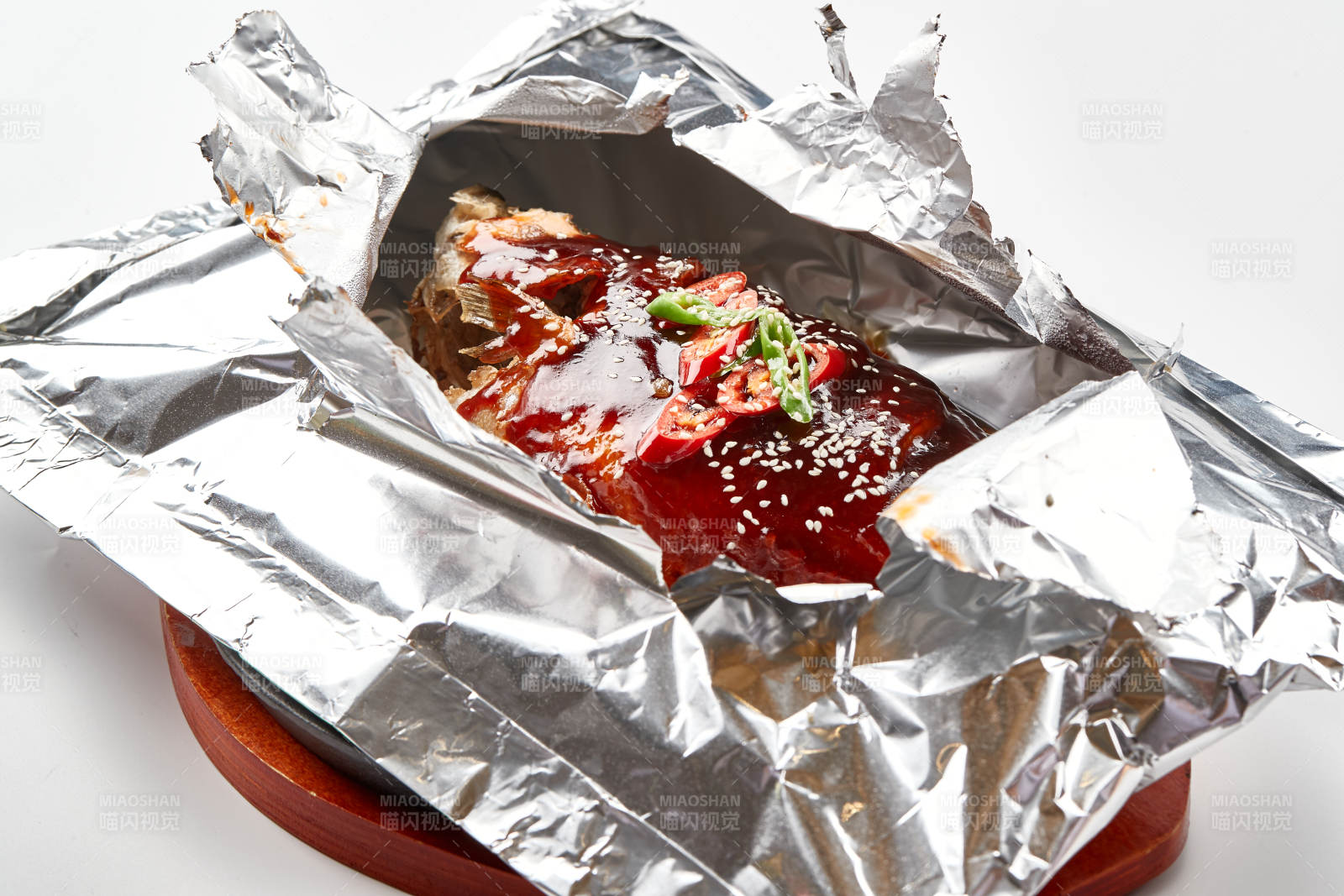 木质托盘摆放的锡纸酱汁烤鲈鱼图片