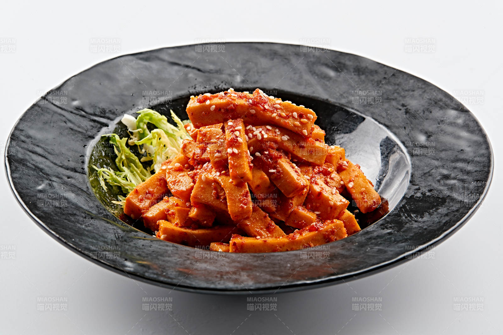 黑色餐具装的秘制甜辣杏鲍菇图片