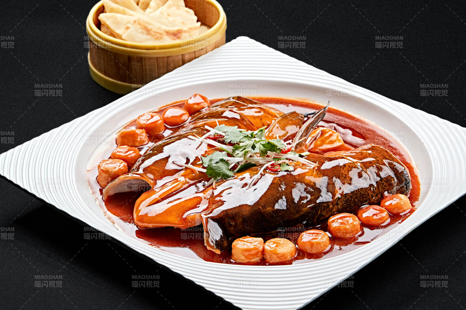 白色瓷盘装的红烧千岛湖大鱼头图片