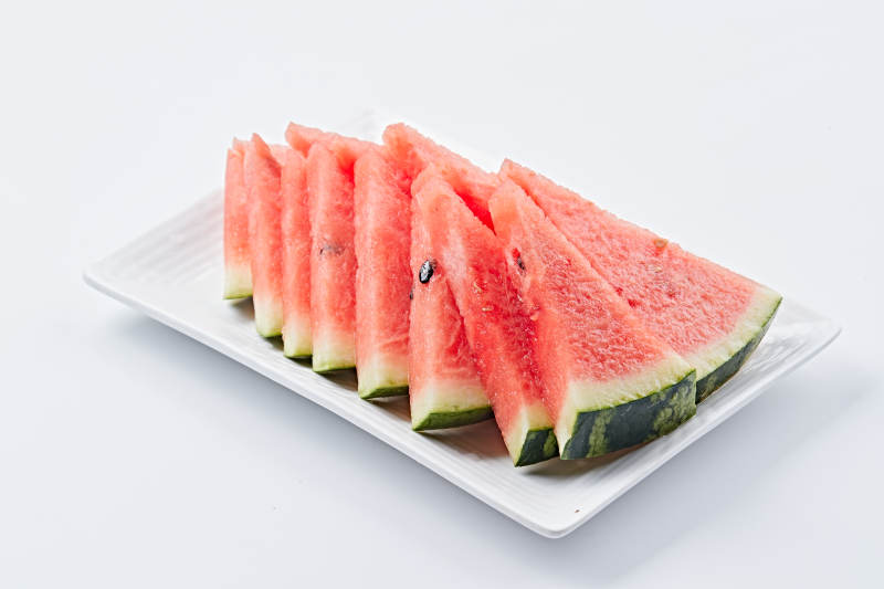 白色瓷盘装的切好的西瓜图片