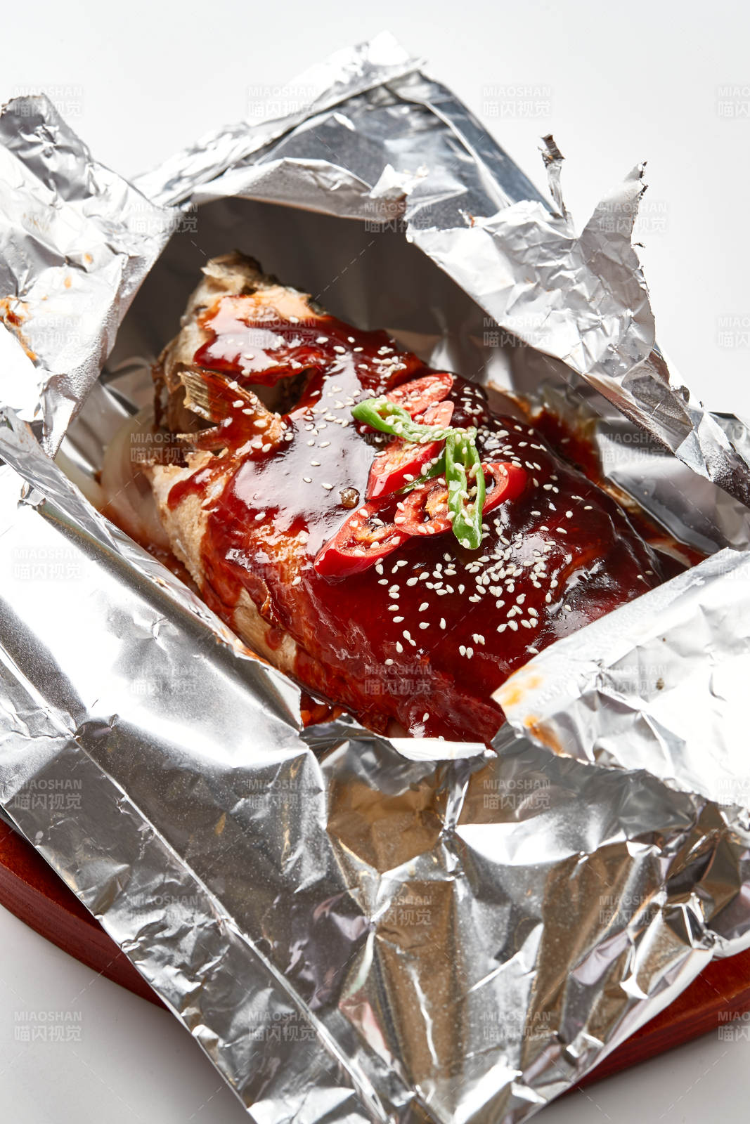 木质托盘摆放的锡纸酱汁烤鲈鱼图片