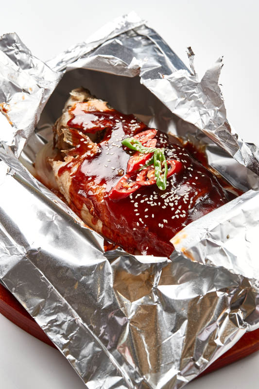 木质托盘摆放的锡纸酱汁烤鲈鱼图片