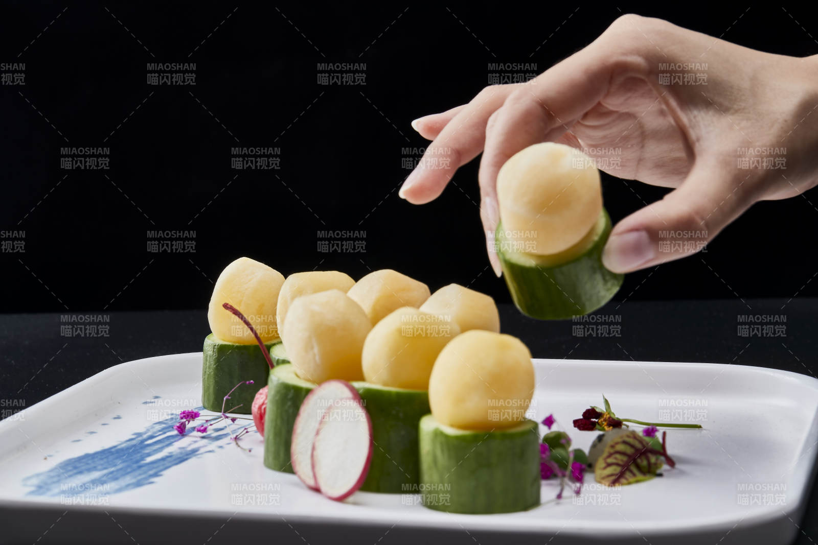 黑色背景上的创意美食手打马铃薯球配乳瓜段图片