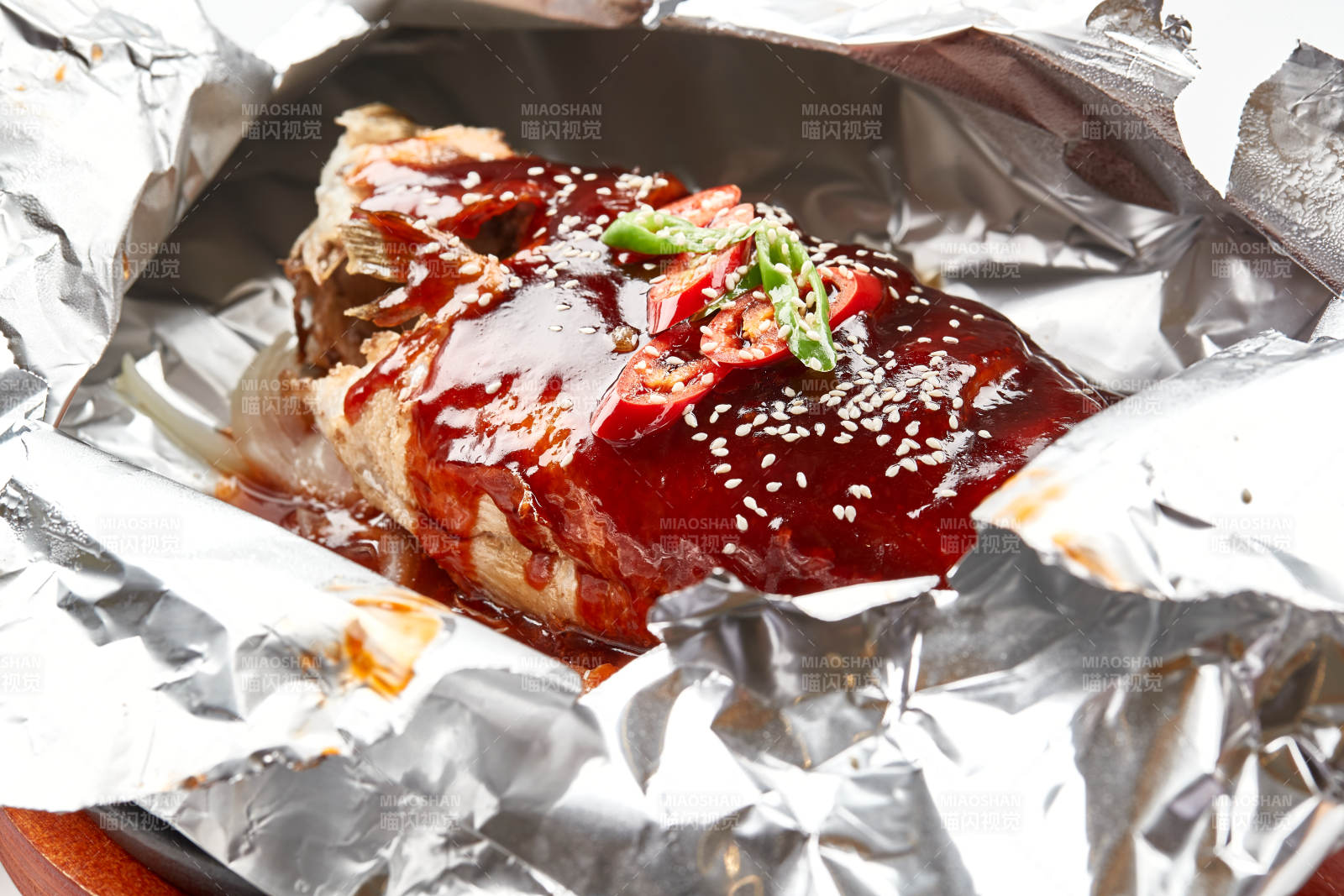 木质托盘摆放的锡纸酱汁烤鲈鱼图片