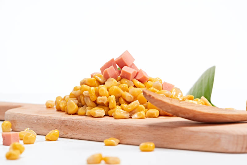 白色背景上的甜玉米粒图片