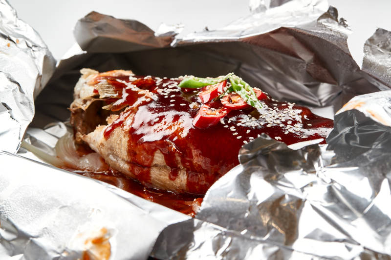 木质托盘摆放的锡纸酱汁烤鲈鱼图片