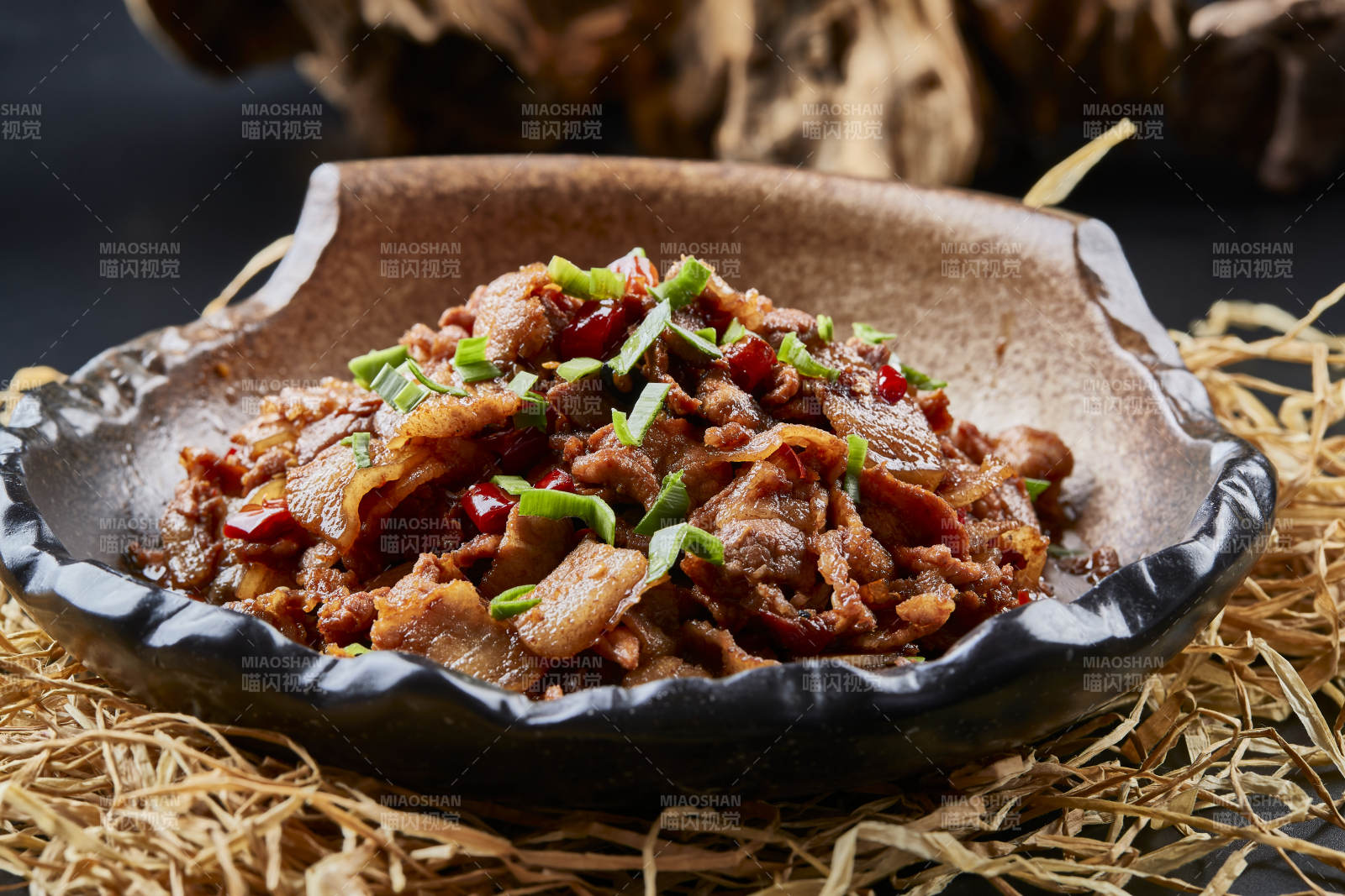 黑色背景上的陶碗装的肥肉炒瘦肉图片