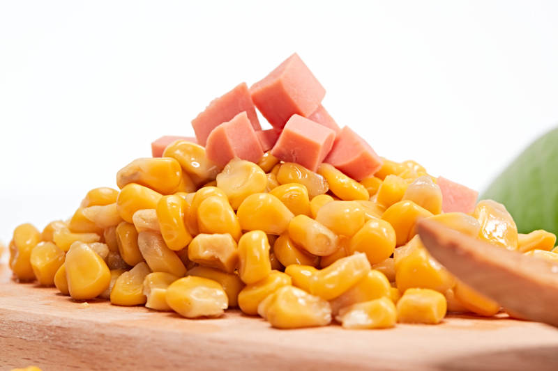 白色背景上的甜玉米粒图片