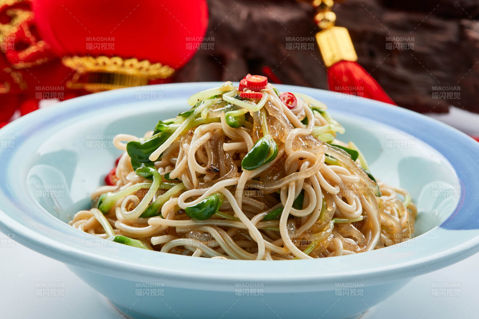 青色瓷餐具装的黑豆苗凉拌莜面饸饹图片