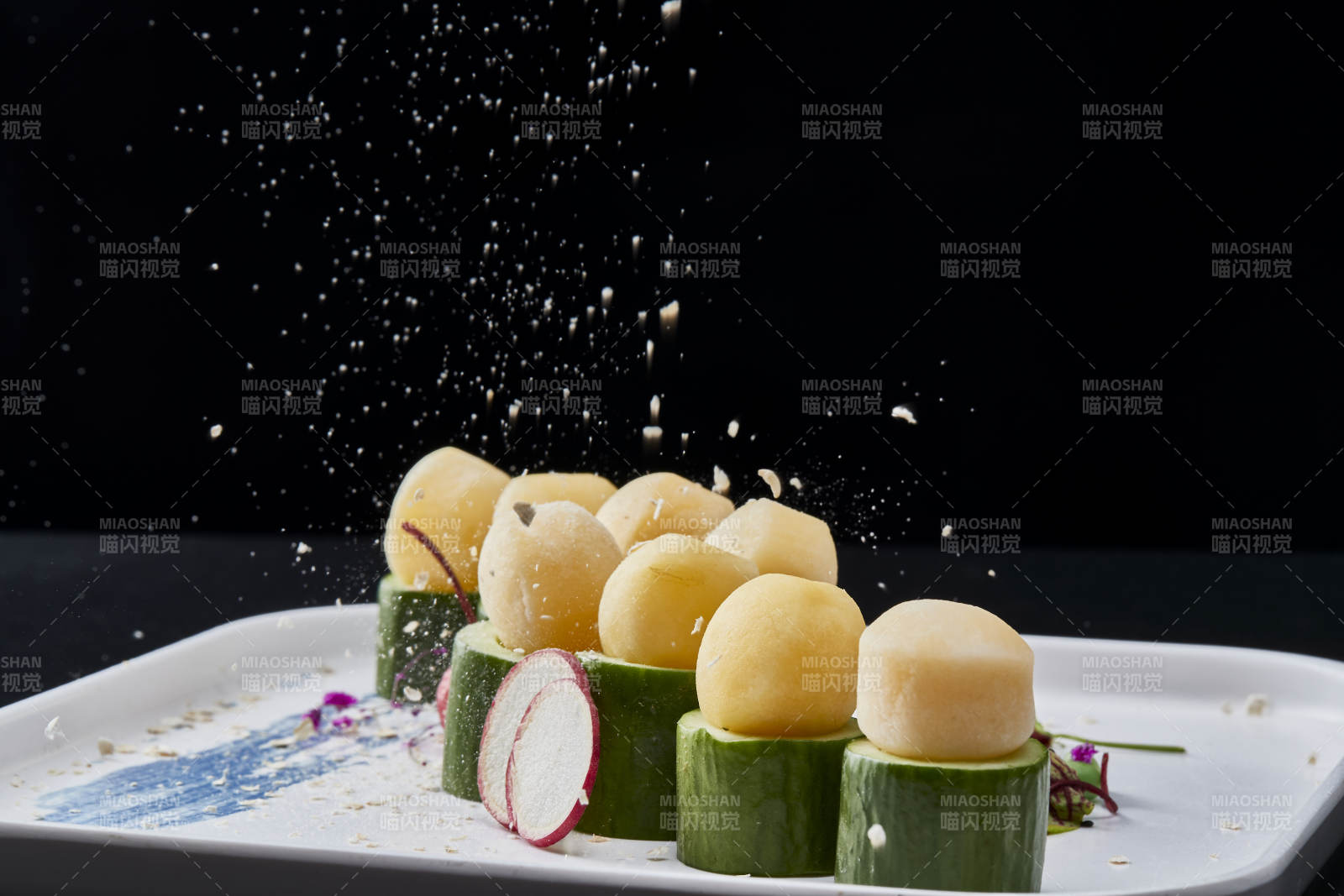 黑色背景上的创意美食手打马铃薯球配乳瓜段图片