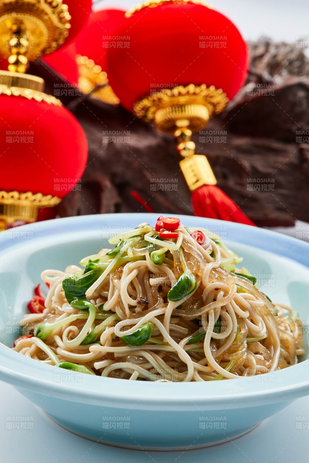 青色瓷餐具装的黑豆苗凉拌莜面饸饹图片