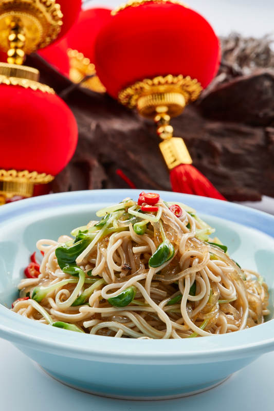 青色瓷餐具装的黑豆苗凉拌莜面饸饹图片