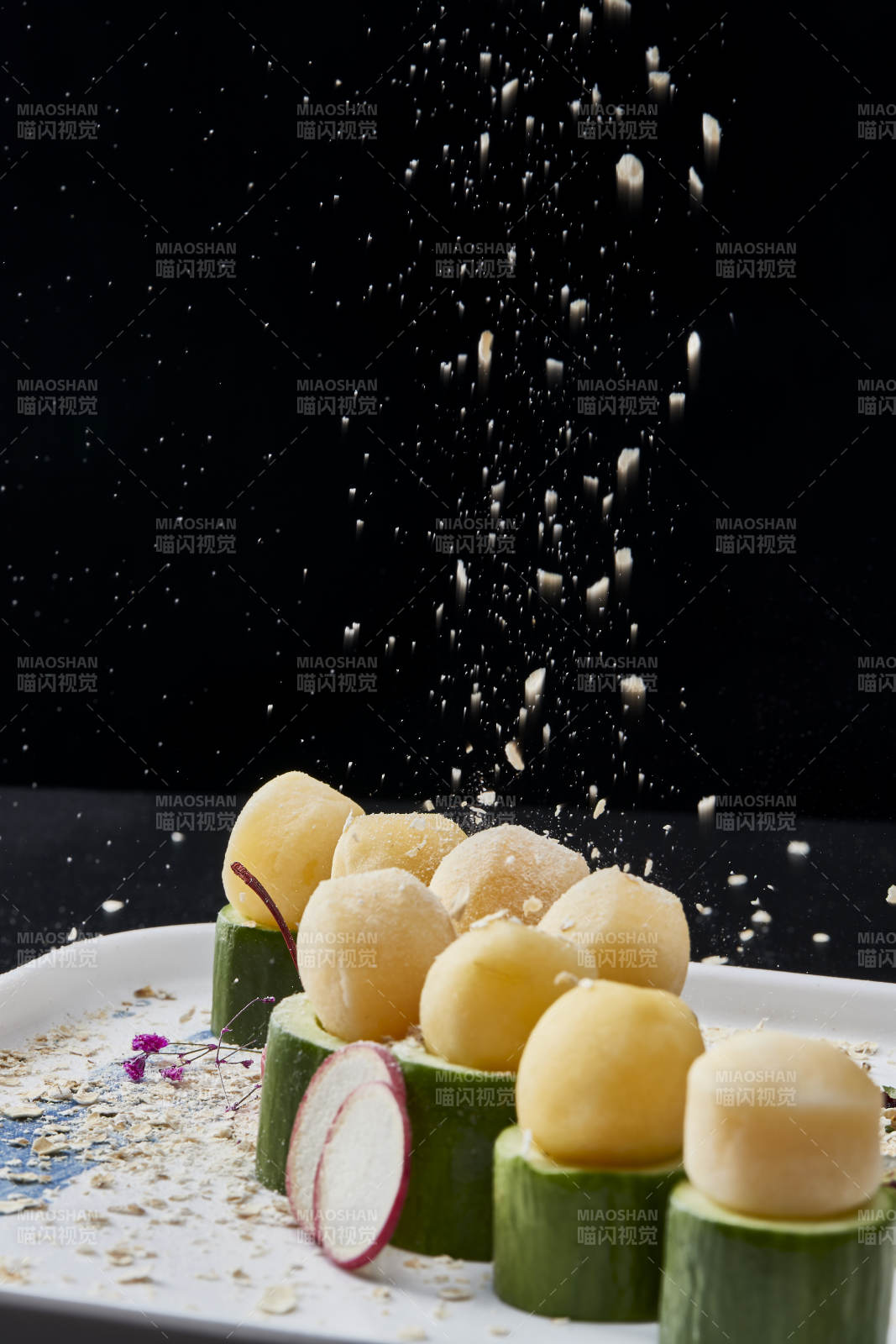 黑色背景上的创意美食手打马铃薯球配乳瓜段图片
