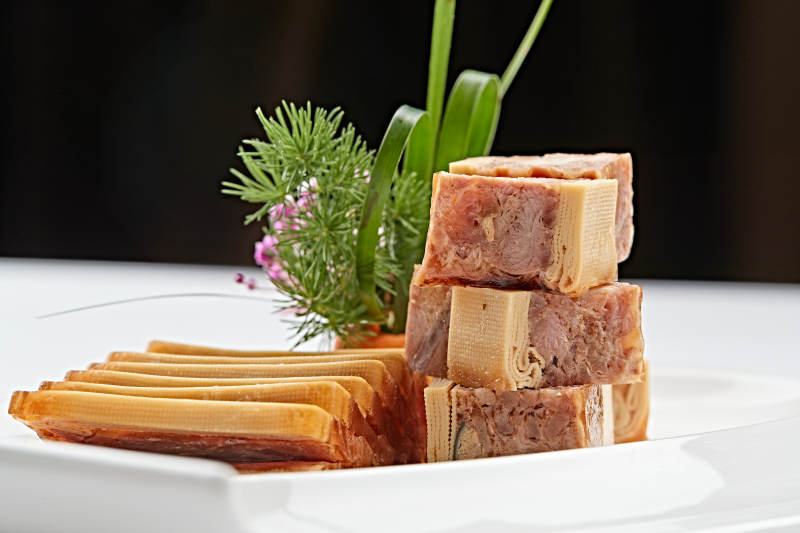 白色瓷盘装的熏豆皮压熏肉图片