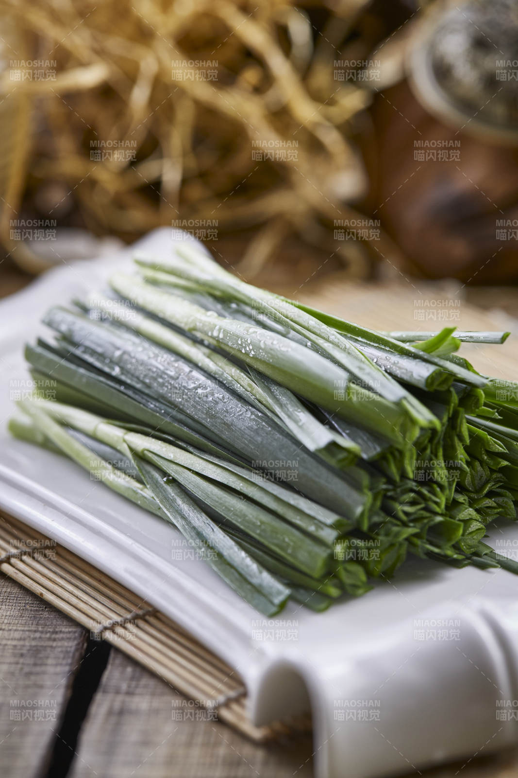 白色瓷盘装的新鲜韭菜图片