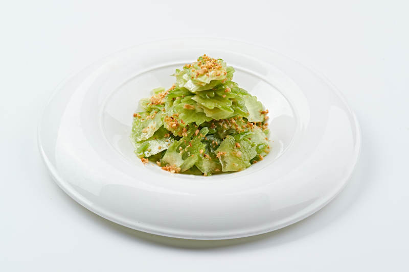 白色瓷盘装的蒜沫凉拌苦瓜片图片