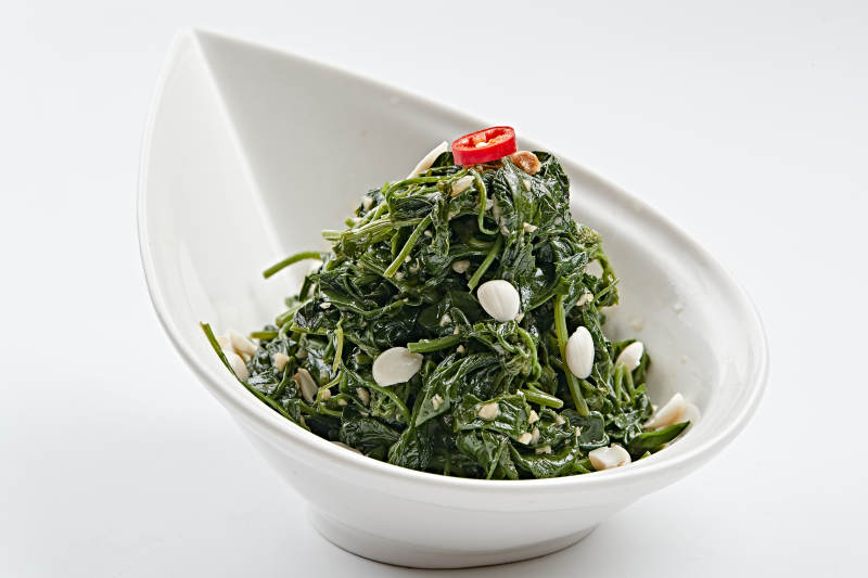 白色瓷盘装的杏仁炝拌野菜图片
