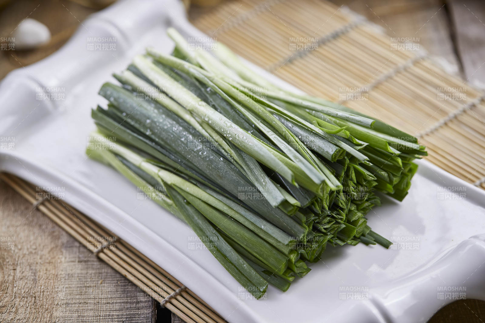 白色瓷盘装的新鲜韭菜图片