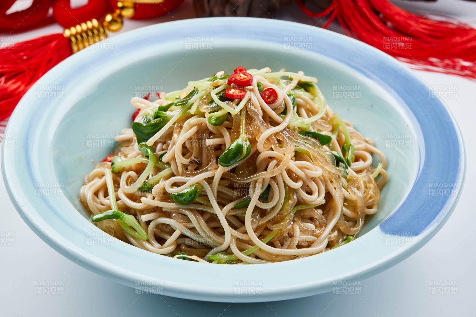 青色瓷餐具装的黑豆苗凉拌莜面饸饹图片