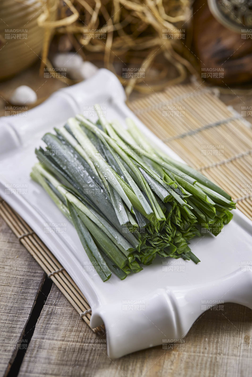 白色瓷盘装的新鲜韭菜图片