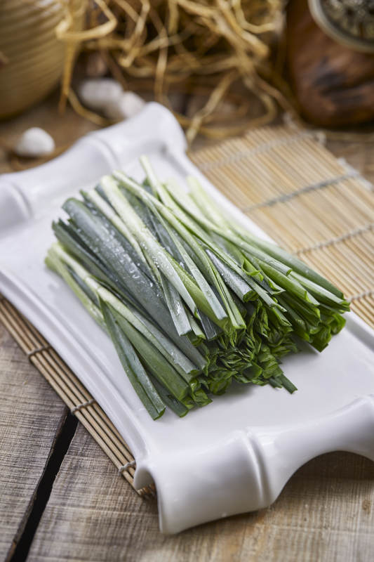白色瓷盘装的新鲜韭菜图片