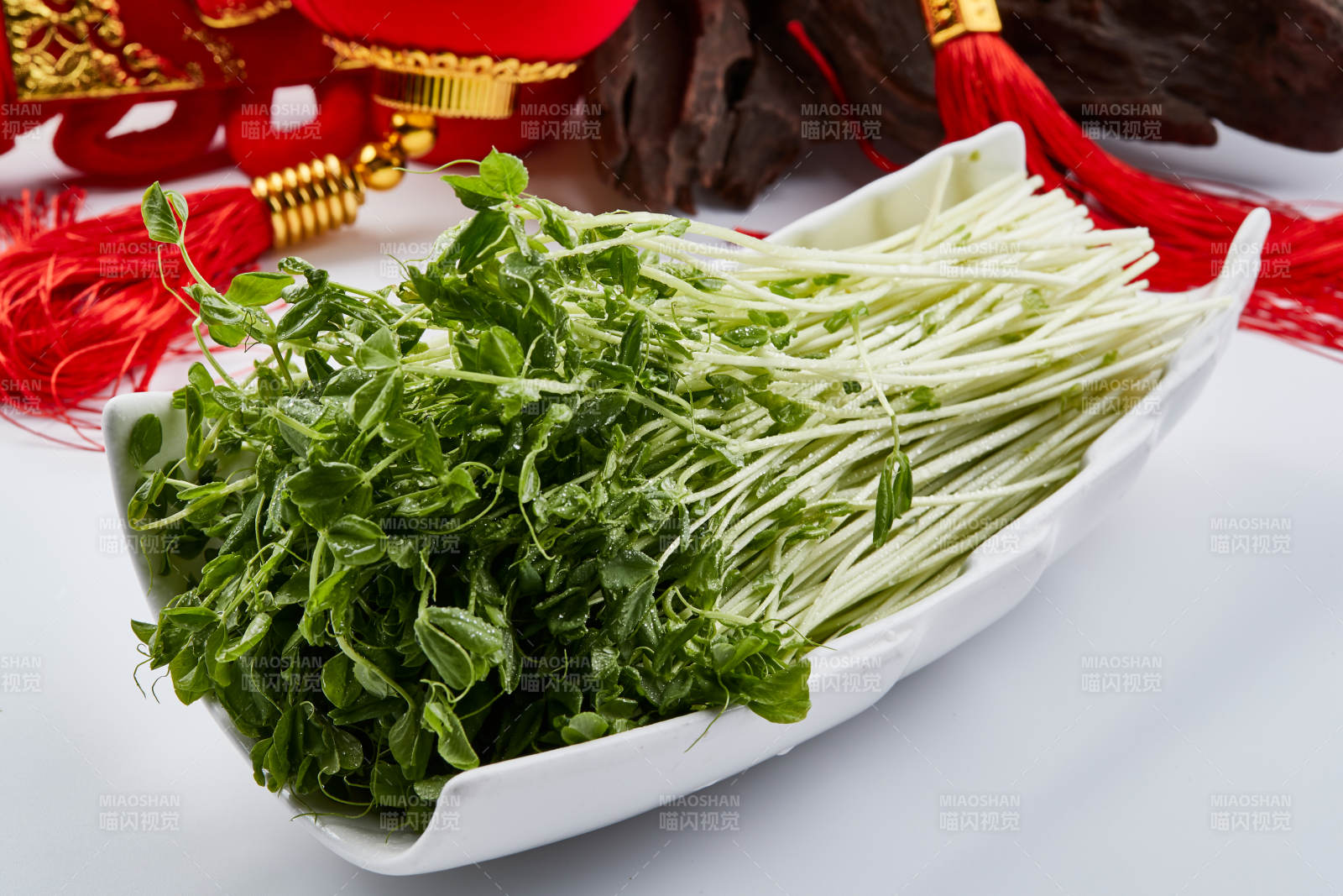 白色瓷盘装的火锅食材香椿苗图片